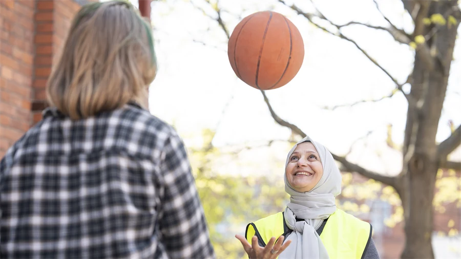 Lärare och elev bollar med en basketboll