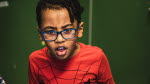 Bild på pojke i glasögon och med röd Spindelmannentröja